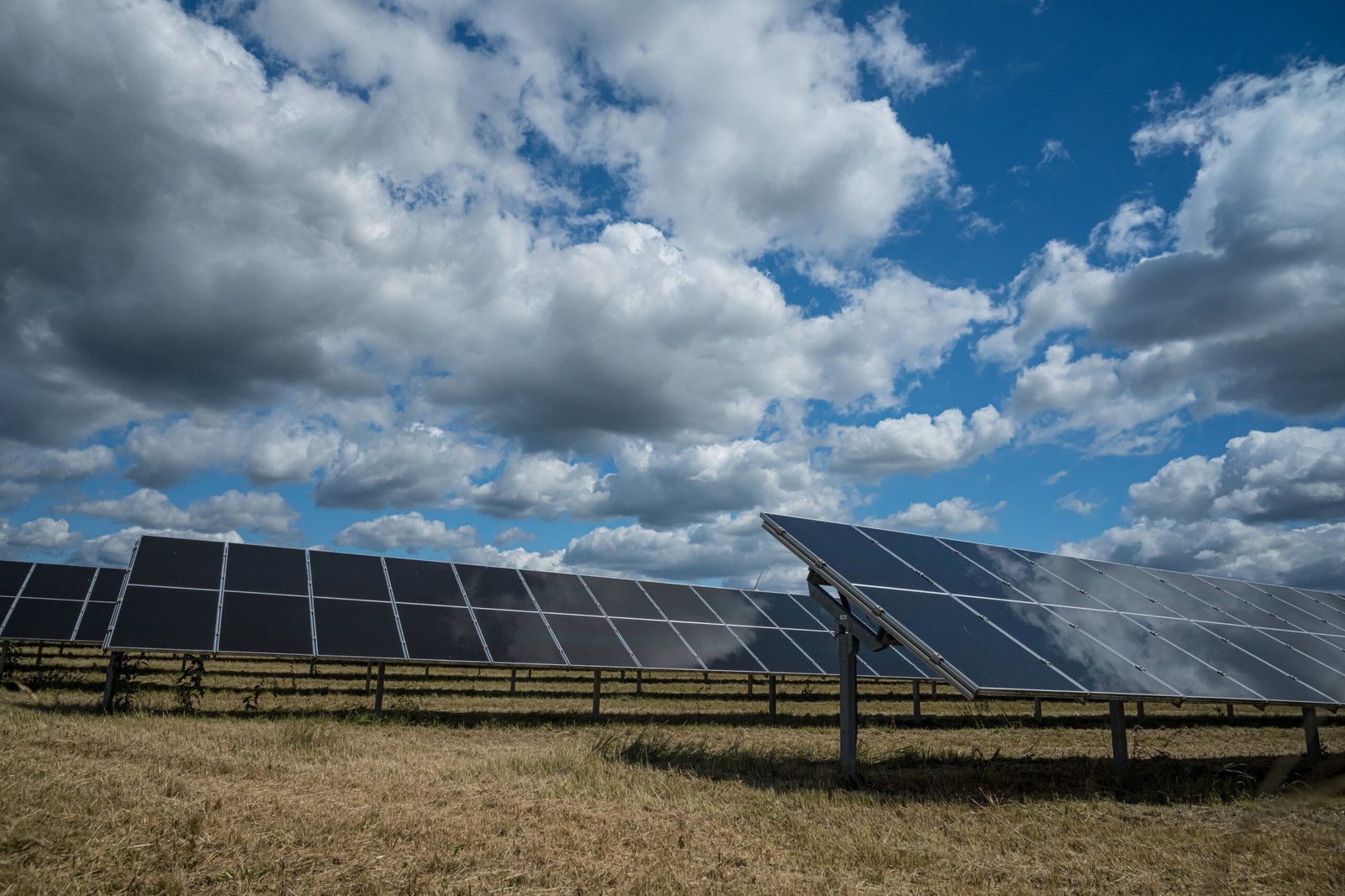 The solar panels used for renewable energy on the field under the sky full of clouds
